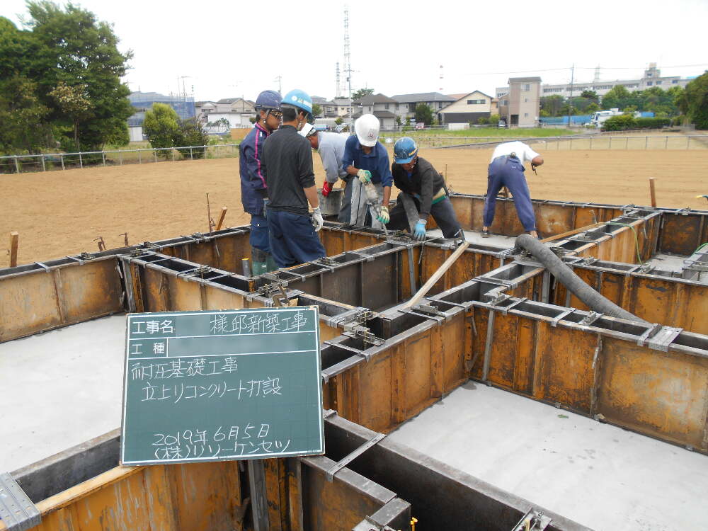 基礎立ち上がり部分のコンクリート打設作業の状況。枠内全てにコンクリートがよくまわる様にバイブレターを掛け、コンクリートを流し込みます。