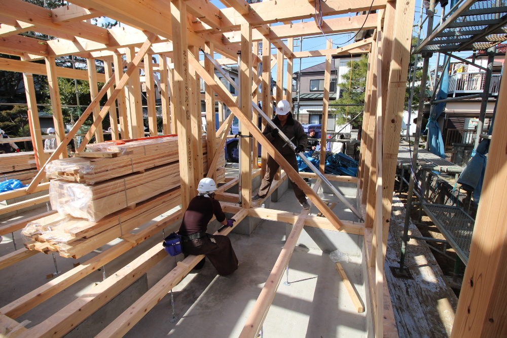 １階部分が梁まで組み終わり、 下げ振りという道具で柱が垂直に建っているかを見て 屋起こしという道具で柱の歪みを矯正します。